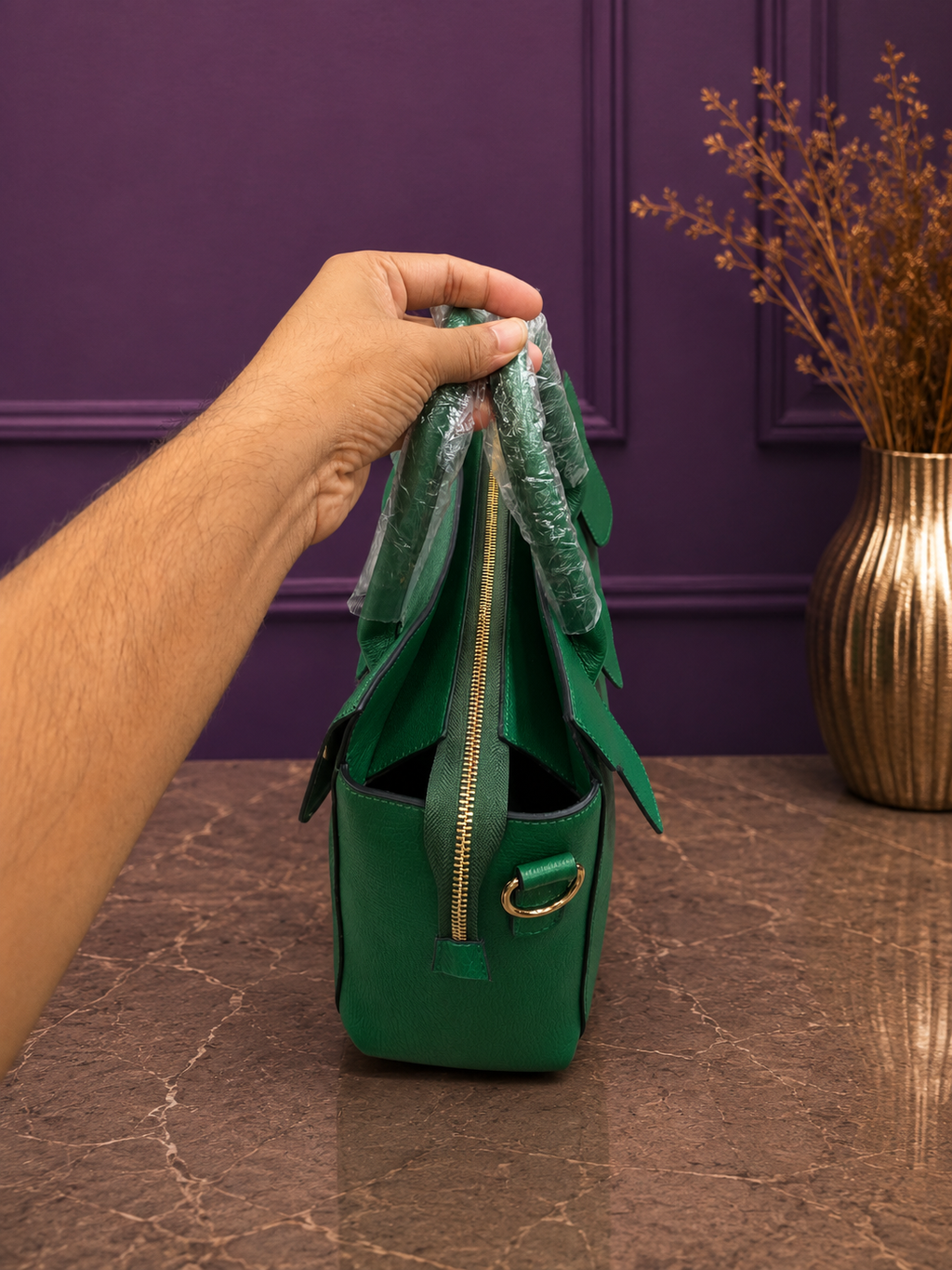 Side view of emerald green structured handbag showing zipper detail