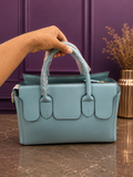Sky blue structured handbag with purple background