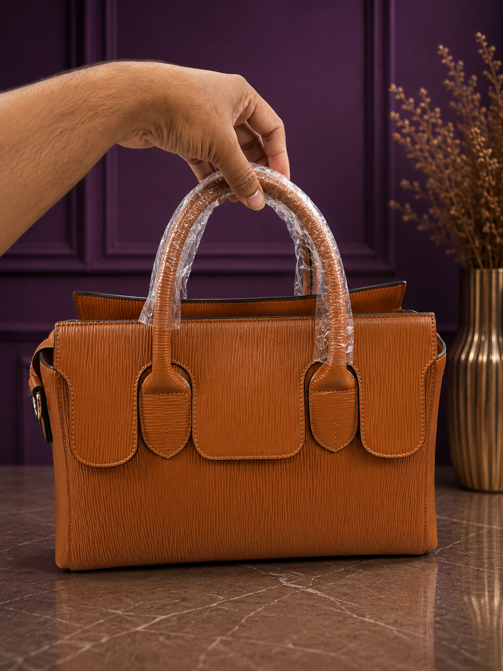 Front view of tan epi texture structured handbag with purple background