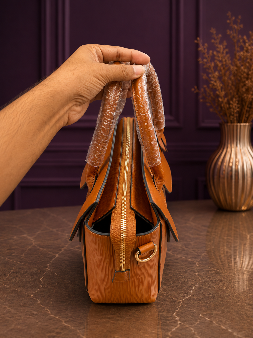 Side view of tan epi texture structured handbag showing zipper detail
