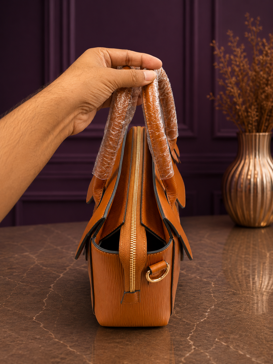 Side view of tan epi texture structured handbag showing zipper detail