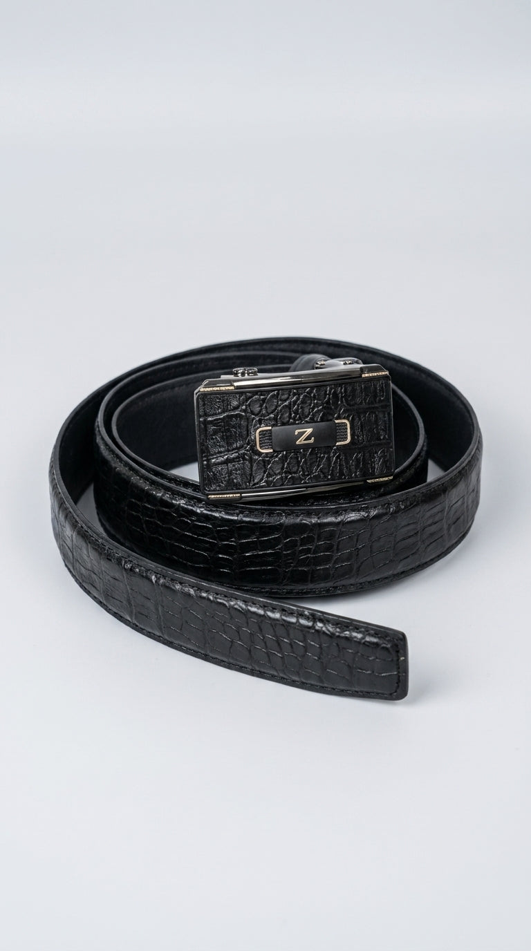 A black crocodile-embossed leather belt with a silver-tone metal buckle featuring a central 'Z' logo, coiled on a light gray background.