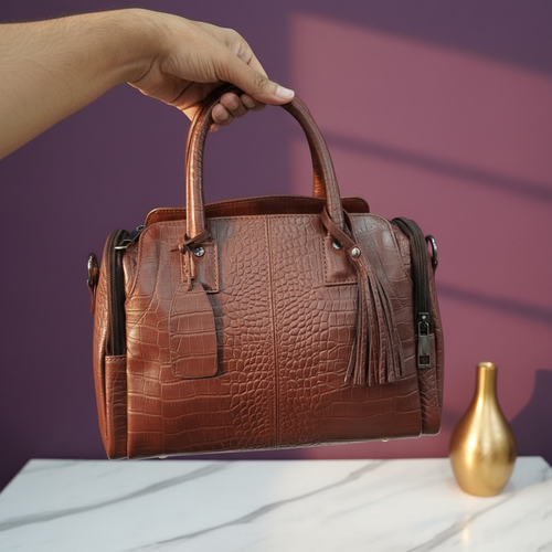 Angle view of brown croco texture handbag with warm purple background